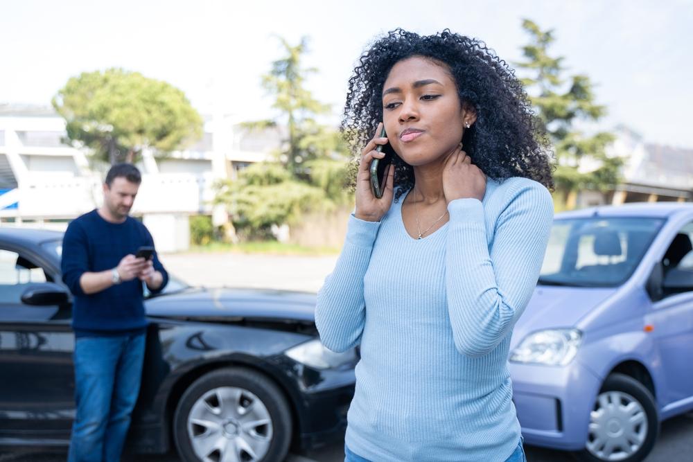 A woman on the phone after an auto accident. A lawyer can explain Georgia’s car accident laws in 2026.