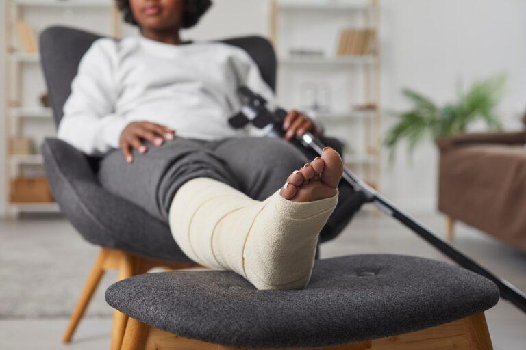 A woman with a bandaged leg relaxes after a dog attack.
