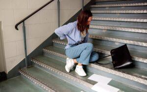 image of a woman who is hurt after falling on stairs, for an article that explains whether a person can receive compensation for a Georgia slip and fall accident.
