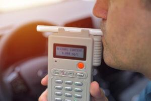 Officer holding a breathalyzer. Can you get a DUI in Georgia with a BAC under 0.08?