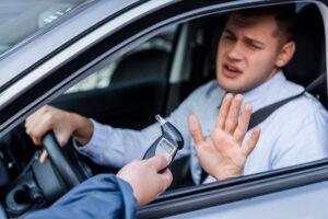 Drunk driver showing refuse gesture to breathalyzer. Can you refuse a breath test in Georgia?